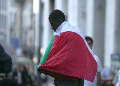 immigrato con bandiera italiana