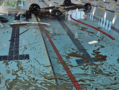 Telecamera di sorveglianza riprende auto di una pensionata che vola in piscina dopo aver sfondato una parete di vetro