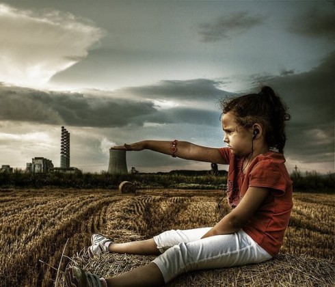 bambino  con mano su ciminiera per fermare lo smog 