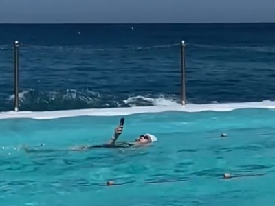 Smartphone in piscina: donna nuota mentre usa il suo cellulare