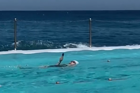Smartphone in piscina: donna nuota mentre usa il suo cellulare