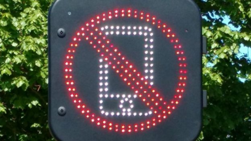 Cellulare alla guida, attenzione in fase di test un nuovo cartello stradale digitale che rivela i segnali della rete mobile