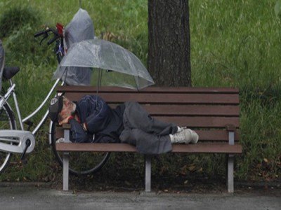 pensionato che dorme su una panchina