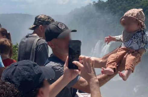 Selfie mania: turista &egrave; stato ripreso dalle telecamere mentre sollevava un neonato oltre la ringhiera di sicurezza alle cascate di Iguazu